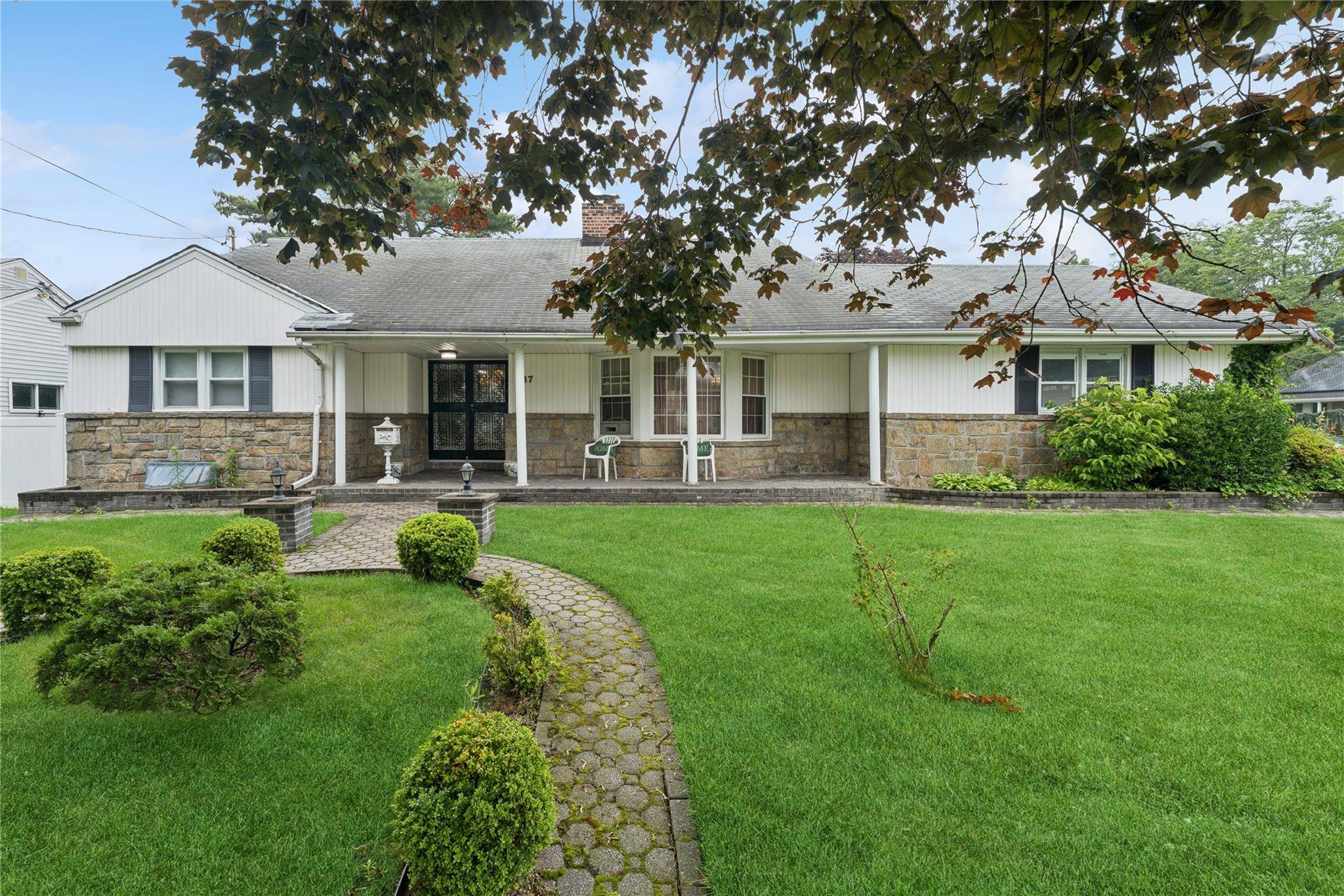 Sprawling Golden Cape Cod on oversized corner lot and treelined street.