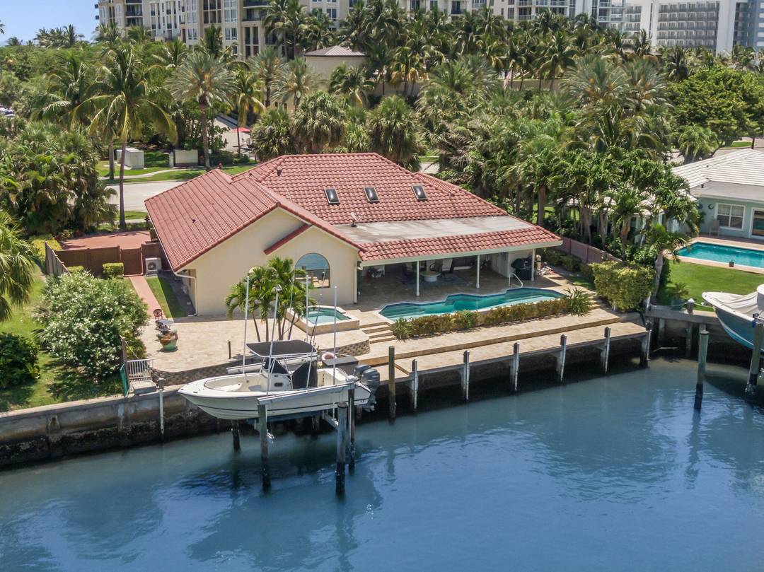 Steps from Singer Island's gorgeous beaches, this waterfront gem offers wide canal and Intracoastal views, 90 feet of deep water frontage, and no fixed bridges, ideal for boaters.