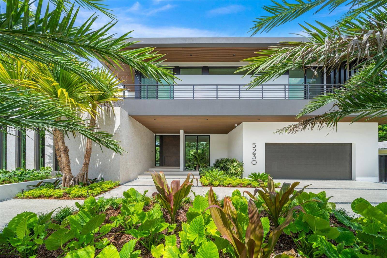 A newly completed tropical modern masterpiece in prestigious High Pines, designed by Preschel Bassan with lush landscaping by Exoticscape.