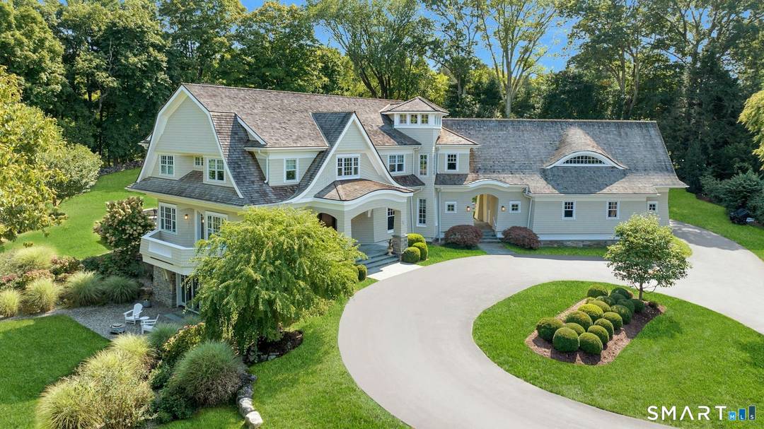 Timeless design meets modern sustainability in this stunning shingle style home, set on 1.