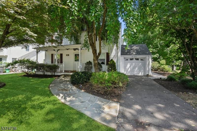 Warm and inviting traditional colonial home with covered front porch offers modern conveniences with remarkable location on a quiet tree lined street overlooking a serene property with a stream at ...
