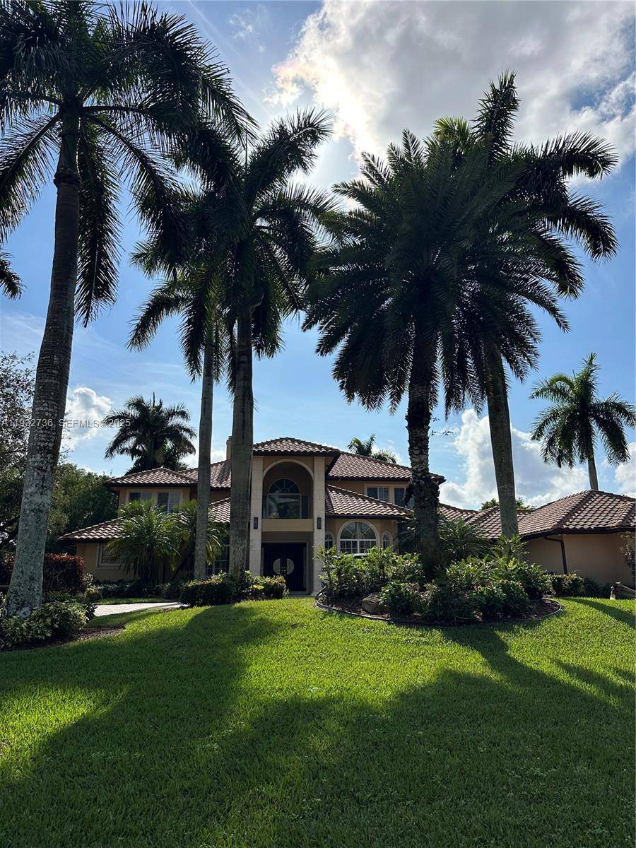 Located in the prestigious guard gated Windmill Lake Estates of Weston, this custom two story estate offers timeless elegance and privacy on a one acre homesite.