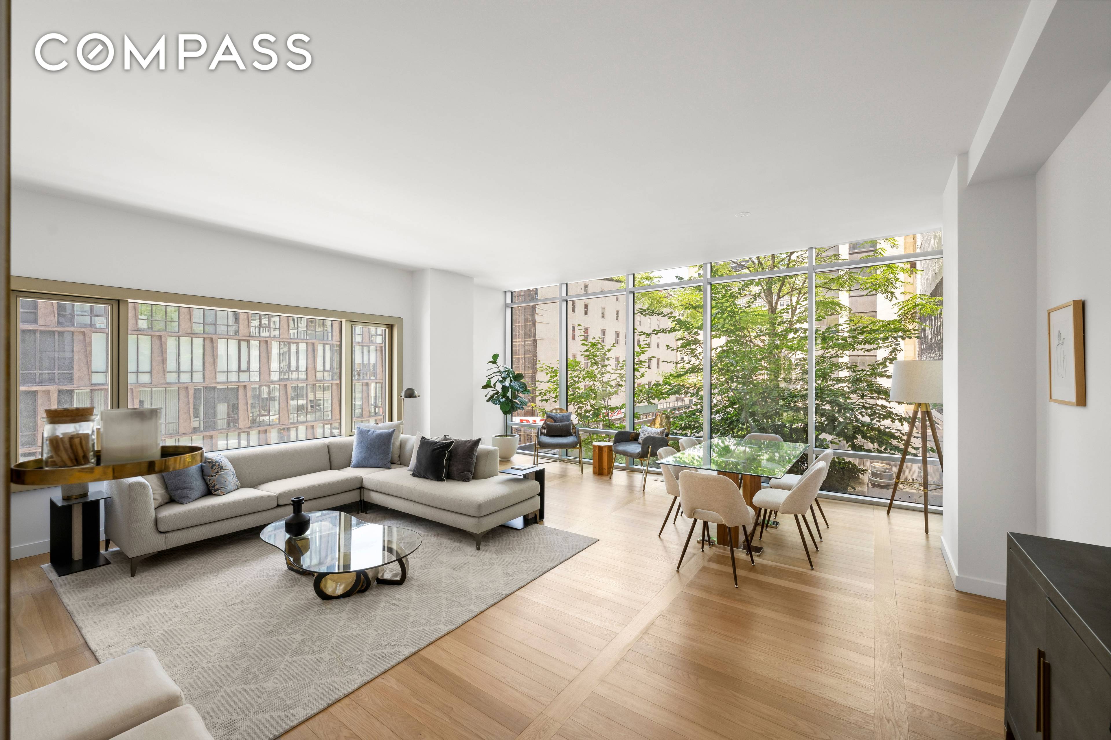Enjoy the quintessential downtown lifestyle in a luxurious Tribeca condo, featuring views of the city skyline and lush greenery.