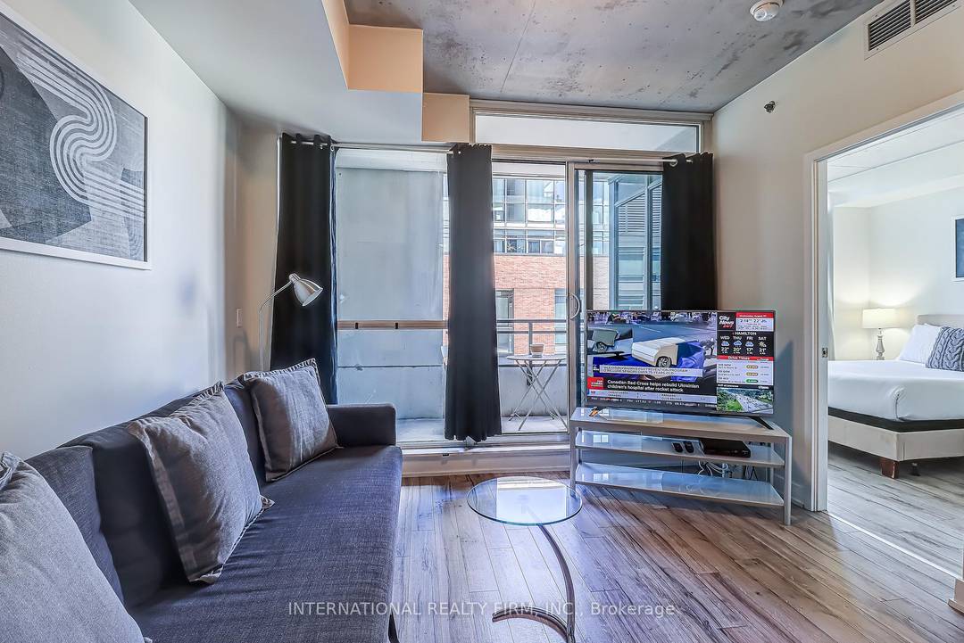 Modern 1 bedroom furnished condo at the Carnaby Lofts in Queen West featuring floor to ceiling windows, a sleek kitchen with built in appliances, in suite laundry, and a private ...