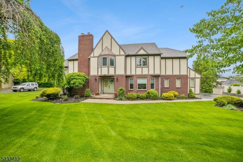 SPLASH ! This pristine Tudor showcases a dramatic cathedral ceiling living room with fireplace, setting the tone for the exceptional spaces throughout.
