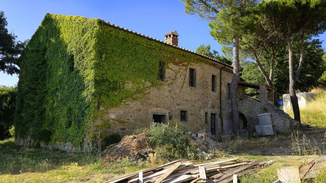 410 sqm country house surrounded by parkland and swimming pool overlooking Lake Trasimeno for sale in the rolling hills of Umbria.