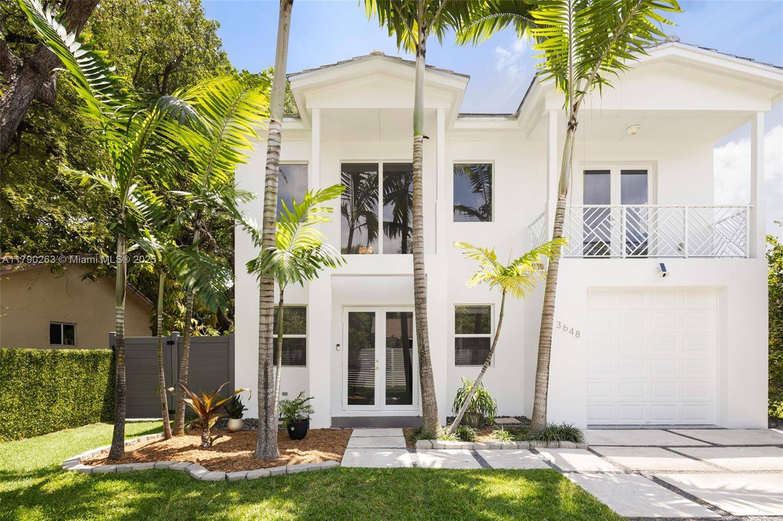 Walk or bike to the historic Grove village from this beautiful 2019 built home, fully gated and surrounded by lush tropical landscaping.