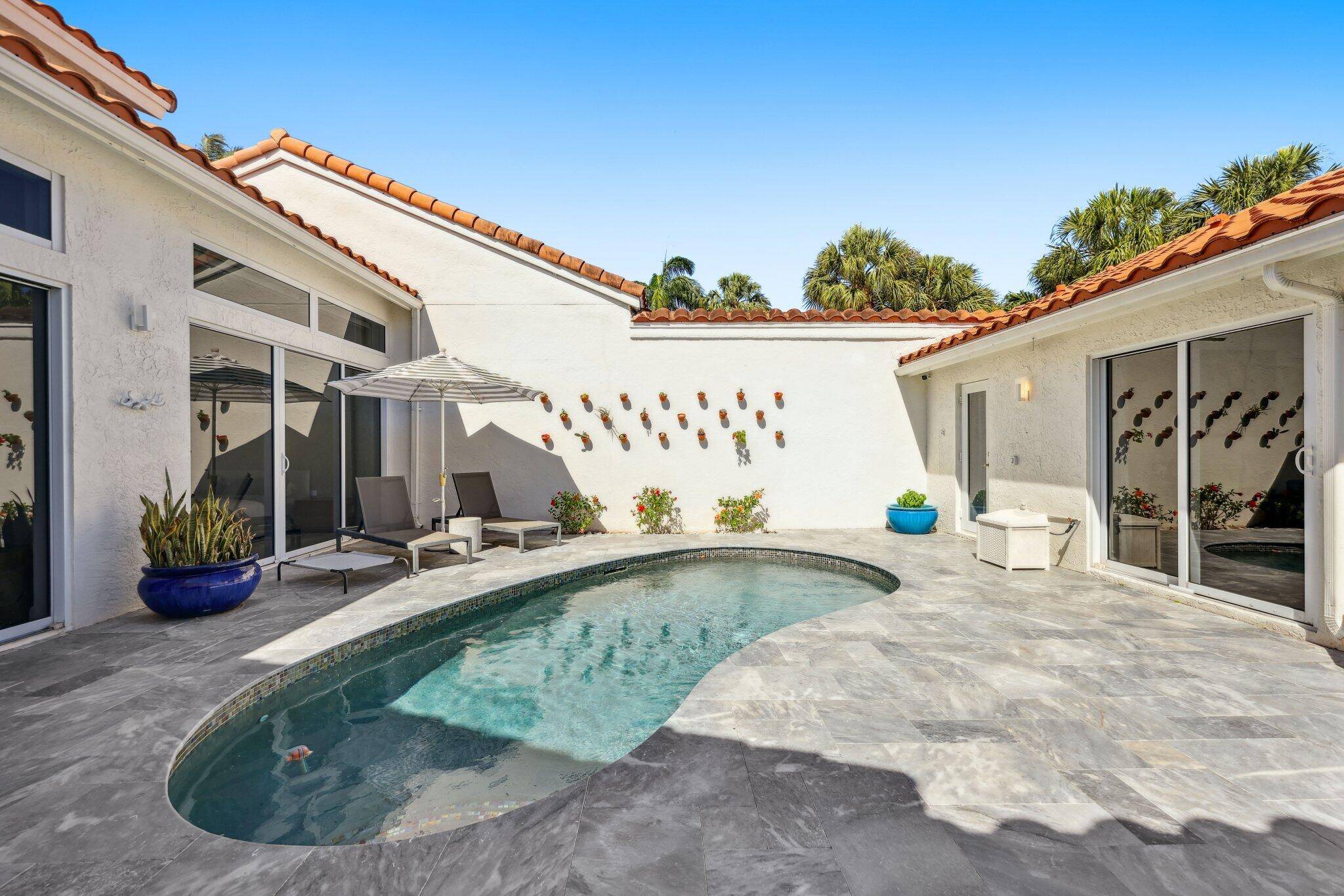 This beautifully designed, modern home is nestled in a gated community in the heart of Boca.