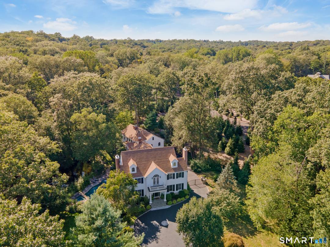 Completely and thoughtfully renovated, this exceptional New Canaan residence blends timeless architecture with refined modern luxury in a magical private setting overlooking the Noroton River and cascading waterfalls.