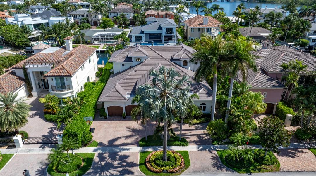Luxe Boca Raton deepwater estate in the desirable Lake Rogers community fronts 80 feet on a deep water canal with a dock offering easy ocean access, desirable for boaters.