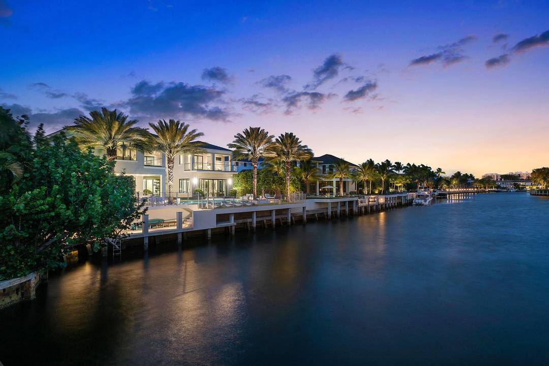 A commanding presence on Royal Palm Yacht Country Club's Grand Canal, 290 South Maya Palm Drive is a masterpiece of modern coastal luxury by Bloomfield Construction.