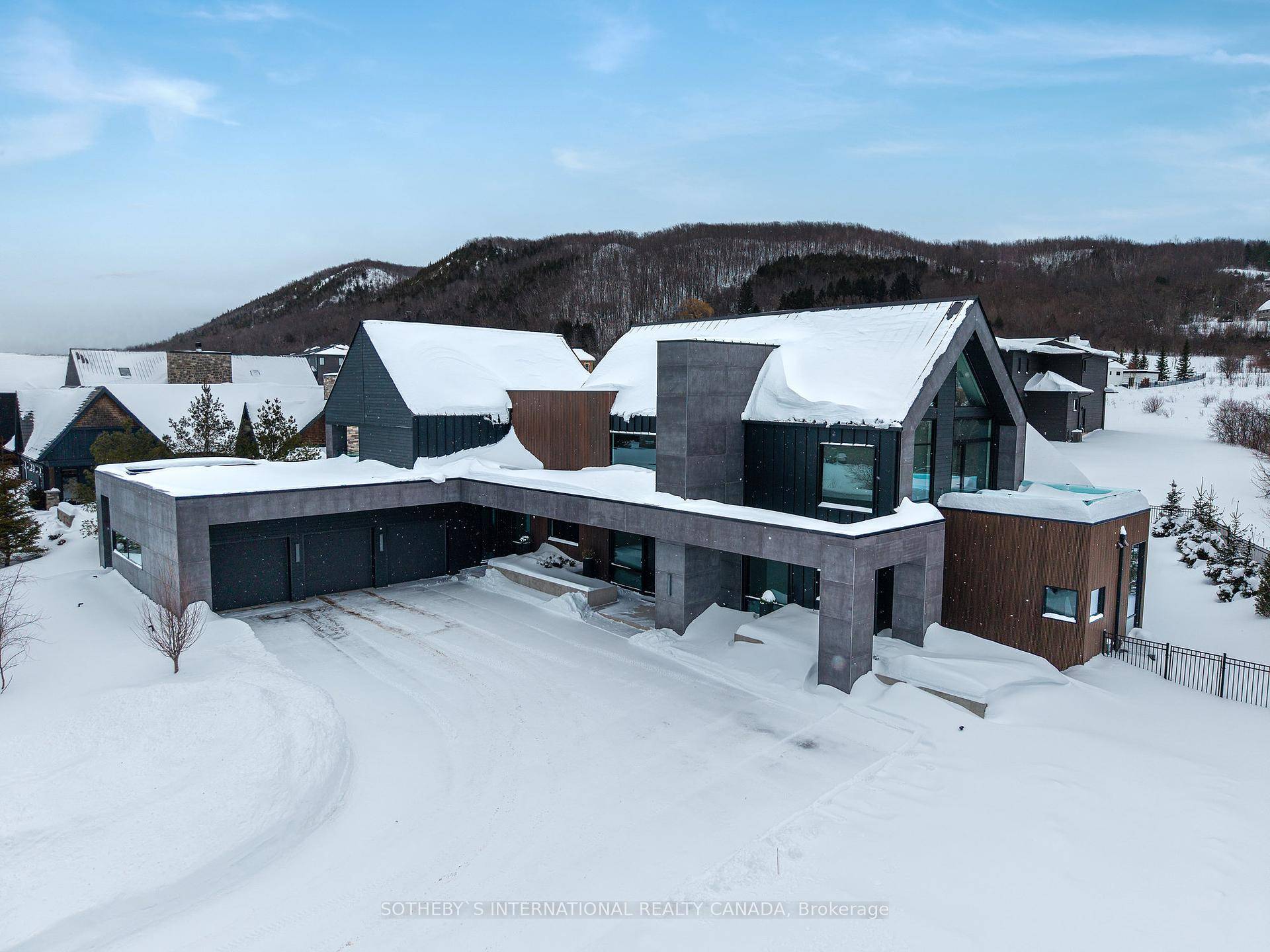 Chic, bold, timeless. This striking custom built residence stands apart with its clean lines, dark grey concrete panels, and warm natural wood accents.