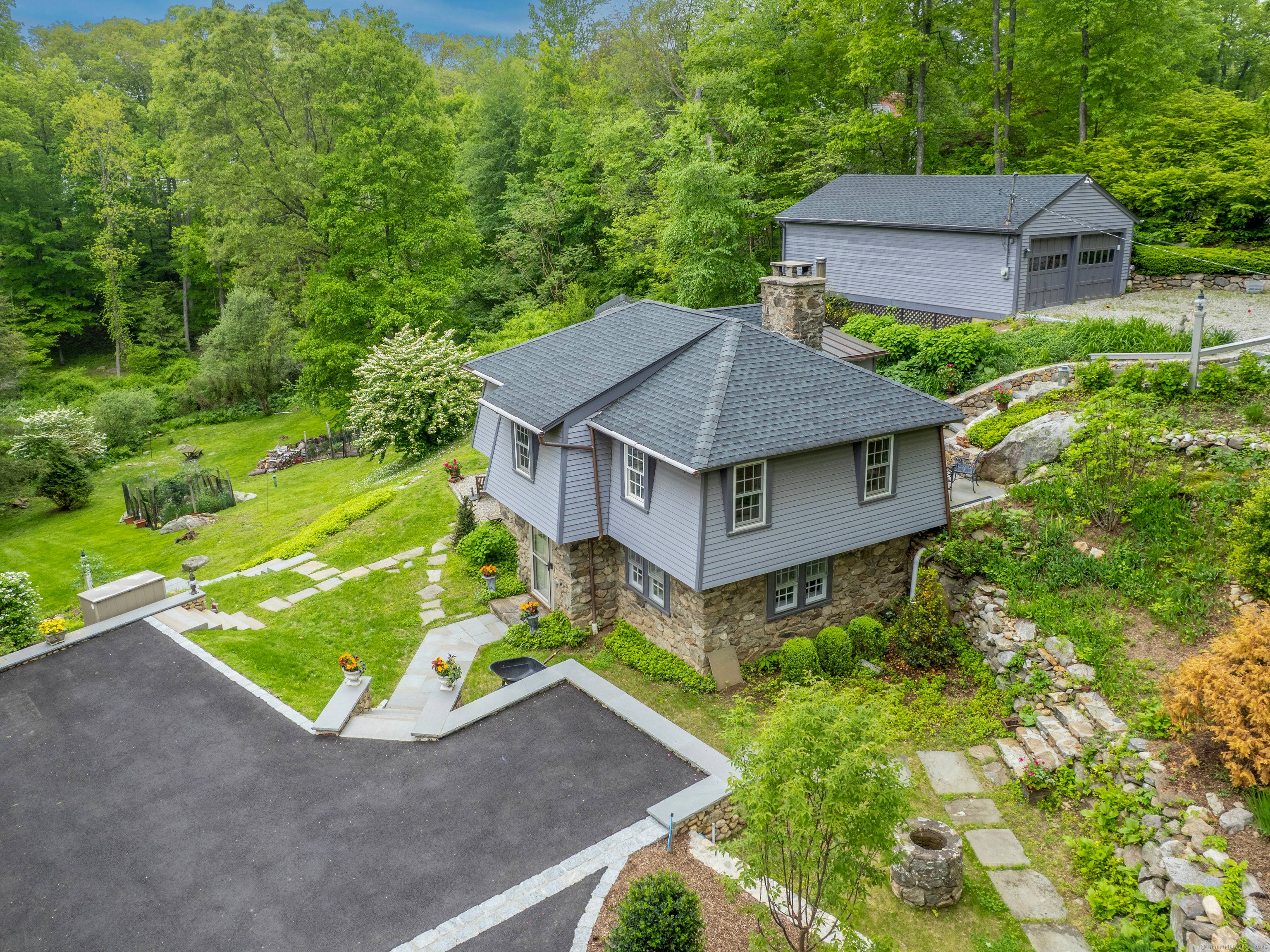 Charming clapboard stone home with idyllic gardens and outdoor living.