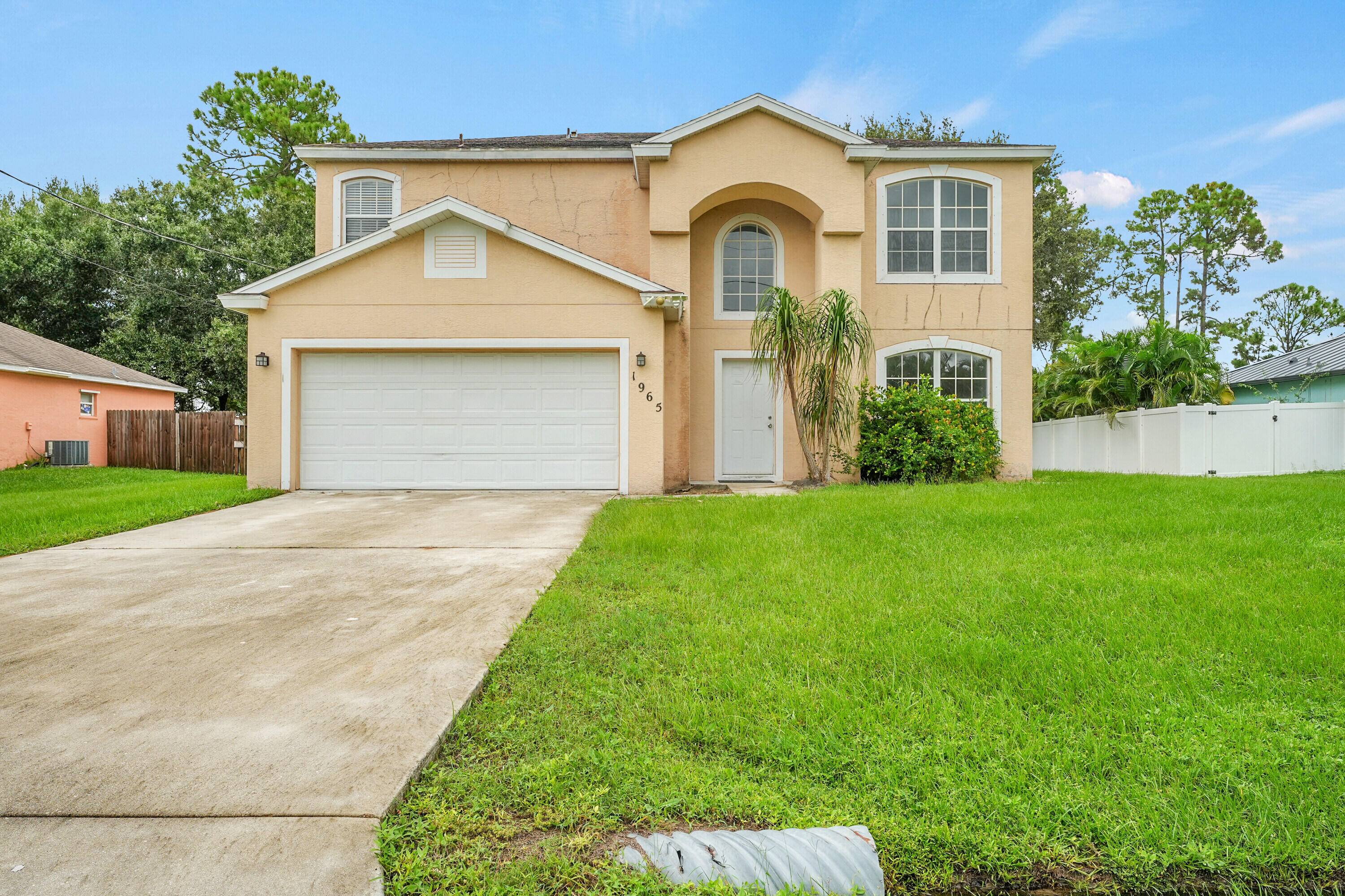 Spacious two story home featuring a formal dining room, sitting room and foyer combo, galley kitchen, family room, and half bath on the main floor.
