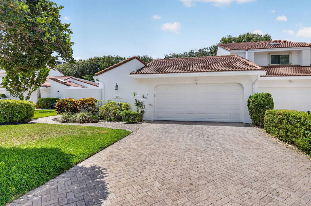 Welcome to 7374 Woodmont Court, a beautifully renovated corner residence in Woodcrest at Boca West Country Club.