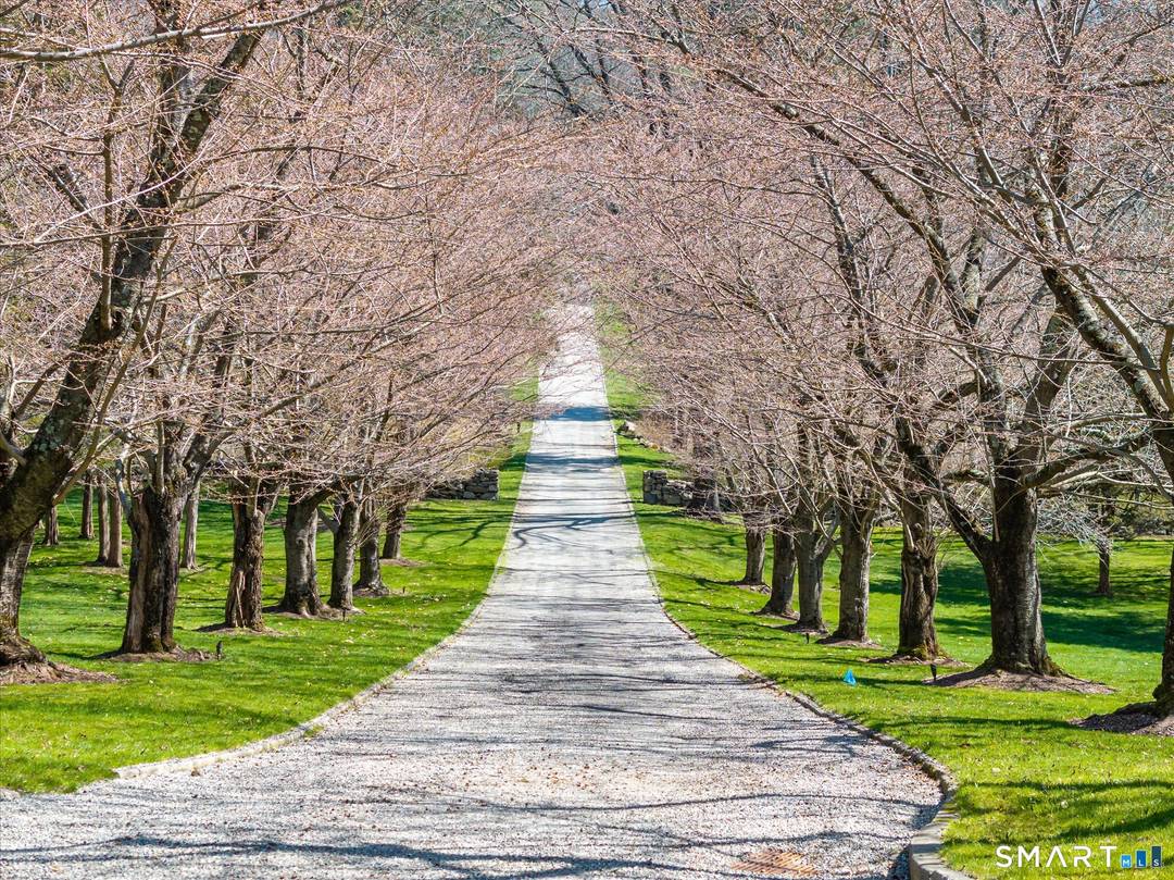 Rock Ledge, a private estate in Weston, is set on nearly five acres surrounded by protected land at the end of a cherry tree lined private drive.