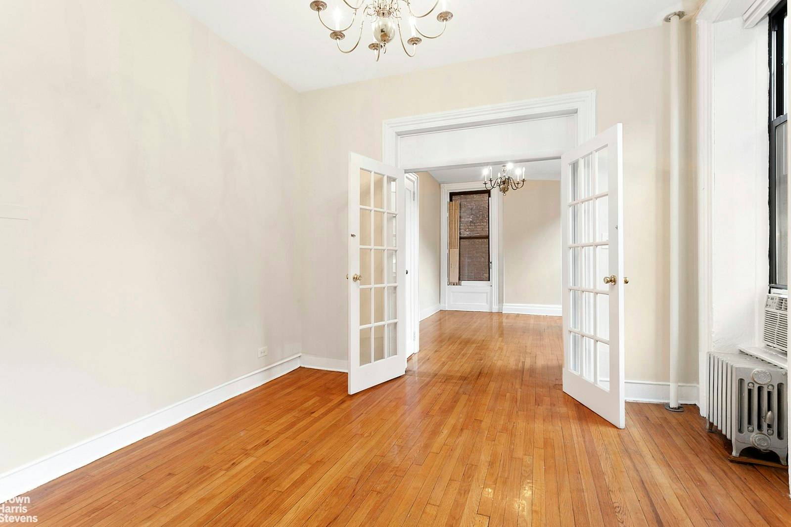 This charming prewar one bedroom, one bathroom apartment boasts elegant 10 foot high ceilings, classic French doors, original moldings, and exquisite vintage chandeliers, adding character and sophistication to the space.