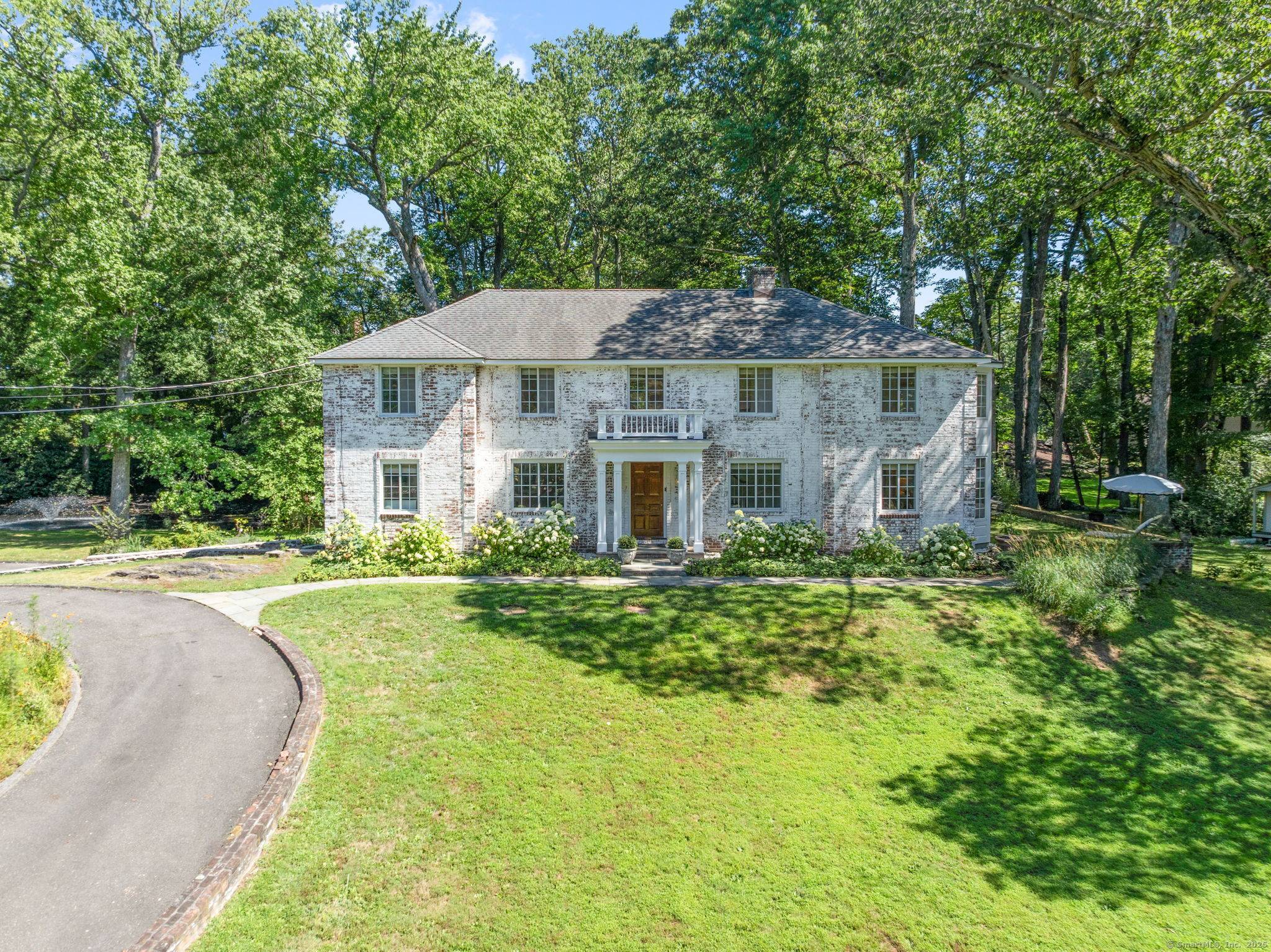 Nestled within the highly sought after Delafield Island Association, 46 Sunswyck Road is a distinguished brick estate set on 1.