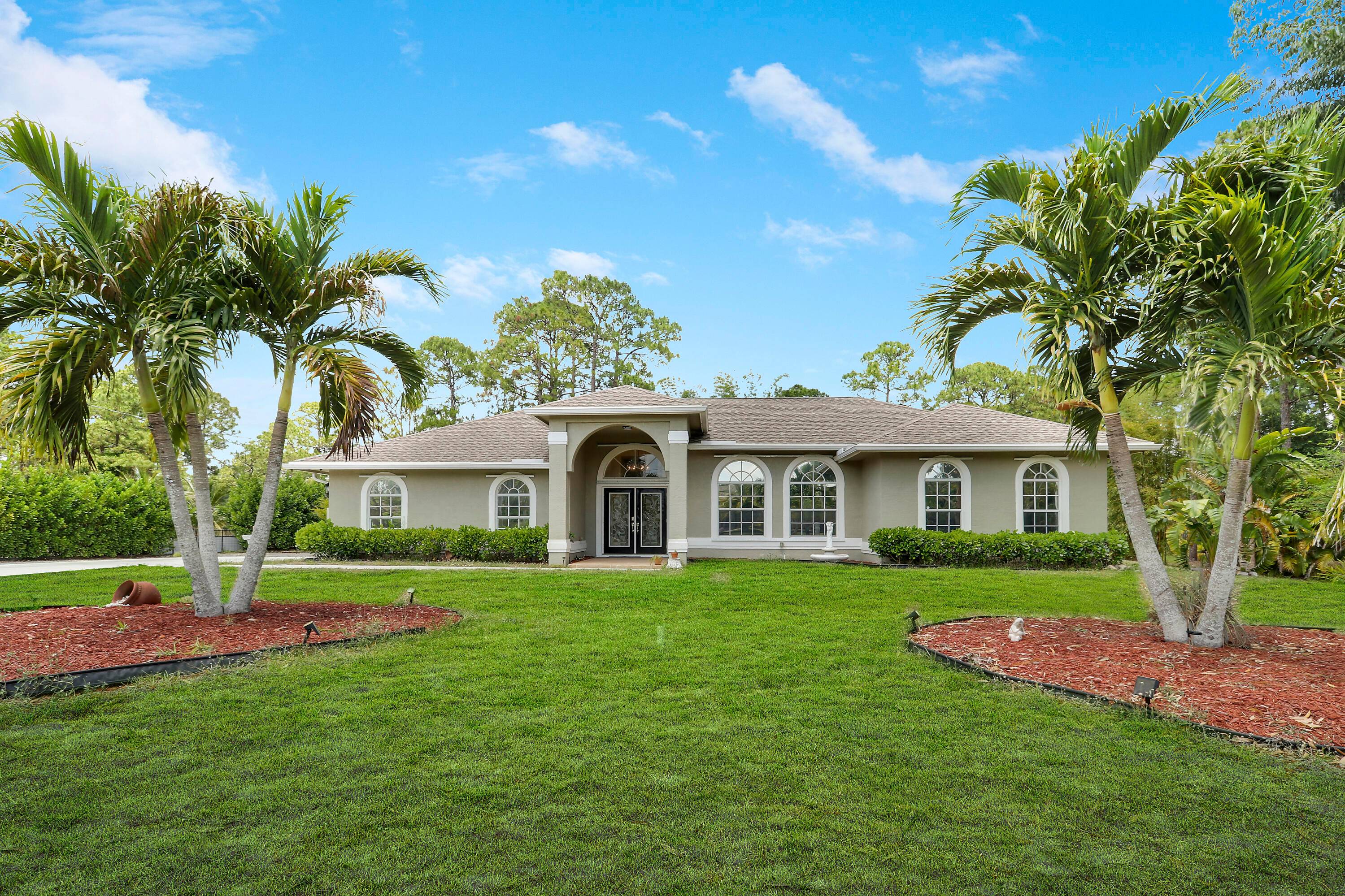 HIGH DRY on a Paved Rd. in the ''Acreage'', this Fully Fenced Gated Pool Home with Fruit Trees is on a lushly wooded 1.