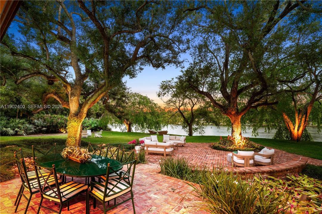 Welcome to an enchanting lakefront residence nestled within the prestigious gated enclave of Banyan Drive in Coral Gables.