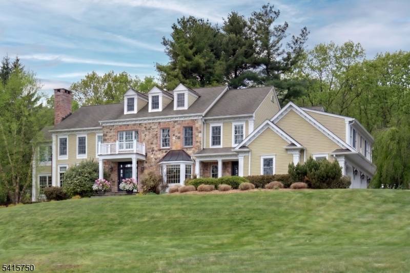 Perched atop 3. 16 scenic acres, this distinguished stone and brick estate overlooks a tranquil spring fed pond, offering privacy, natural beauty, and refined living.