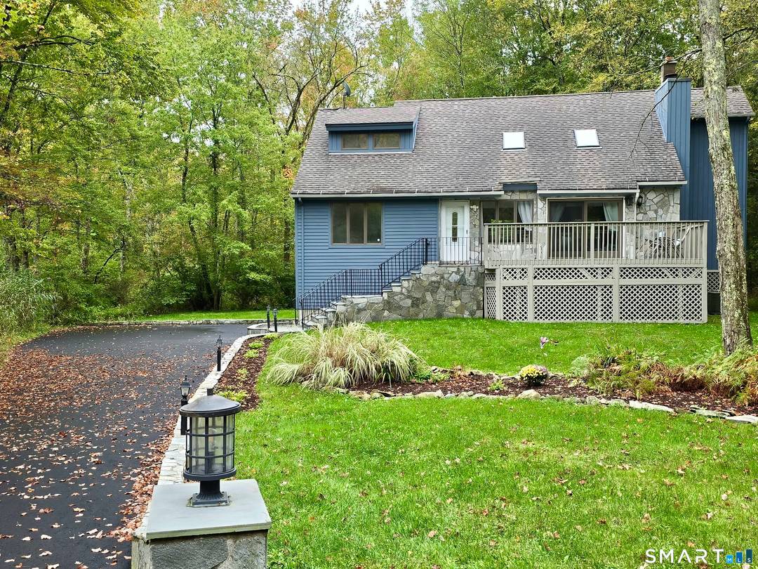 Set on a desirable second tier lot within the Woodridge Lake community, this four bedroom, two and a half bath residence offers peaceful lake views and a private wooded backdrop.