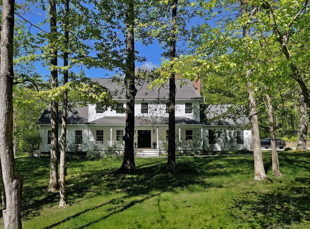 Set on 7 private acres directly across from protected conservation land, this beautifully renovated home offers peaceful wooded views, exceptional privacy, and modern comfort in a prime Sharon location.