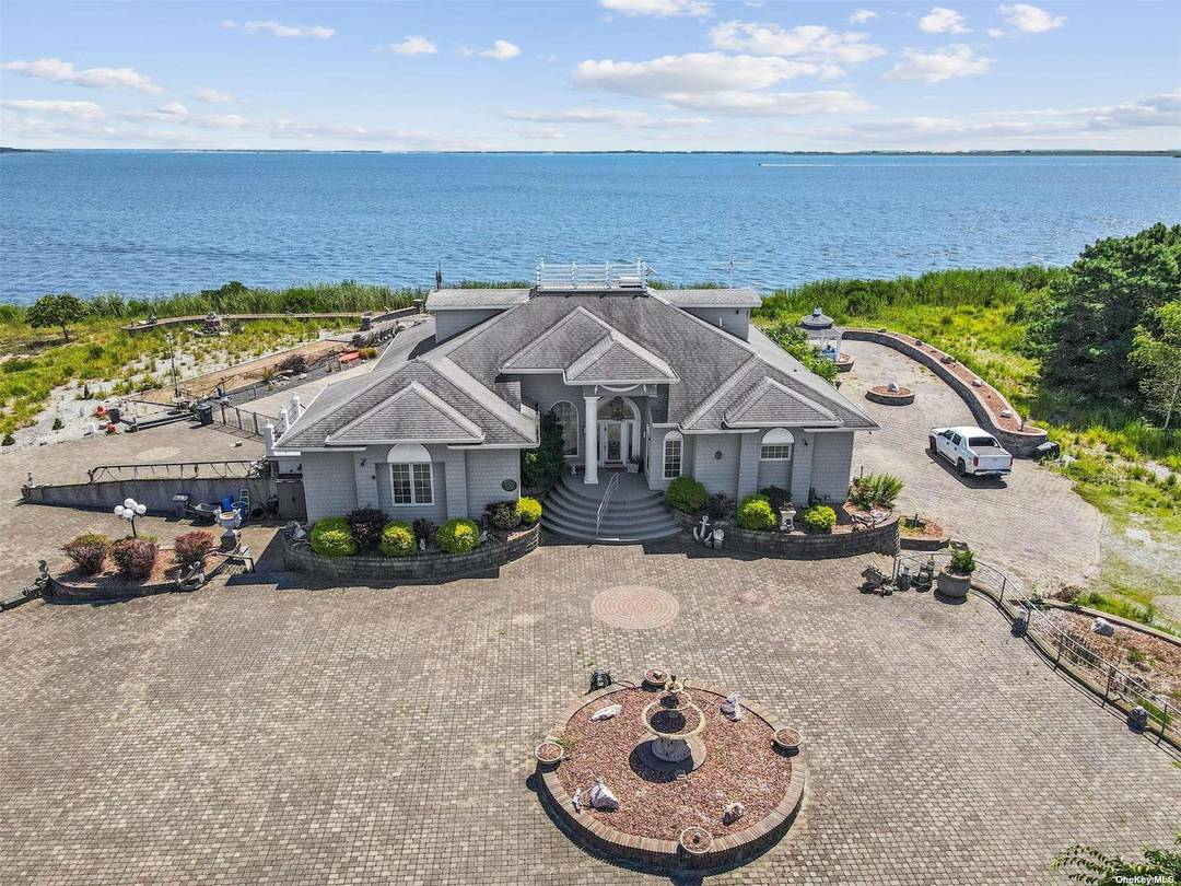Experience the ultimate in serene waterfront living with this nearly 8 acre custom built residence on the Great South Bay.