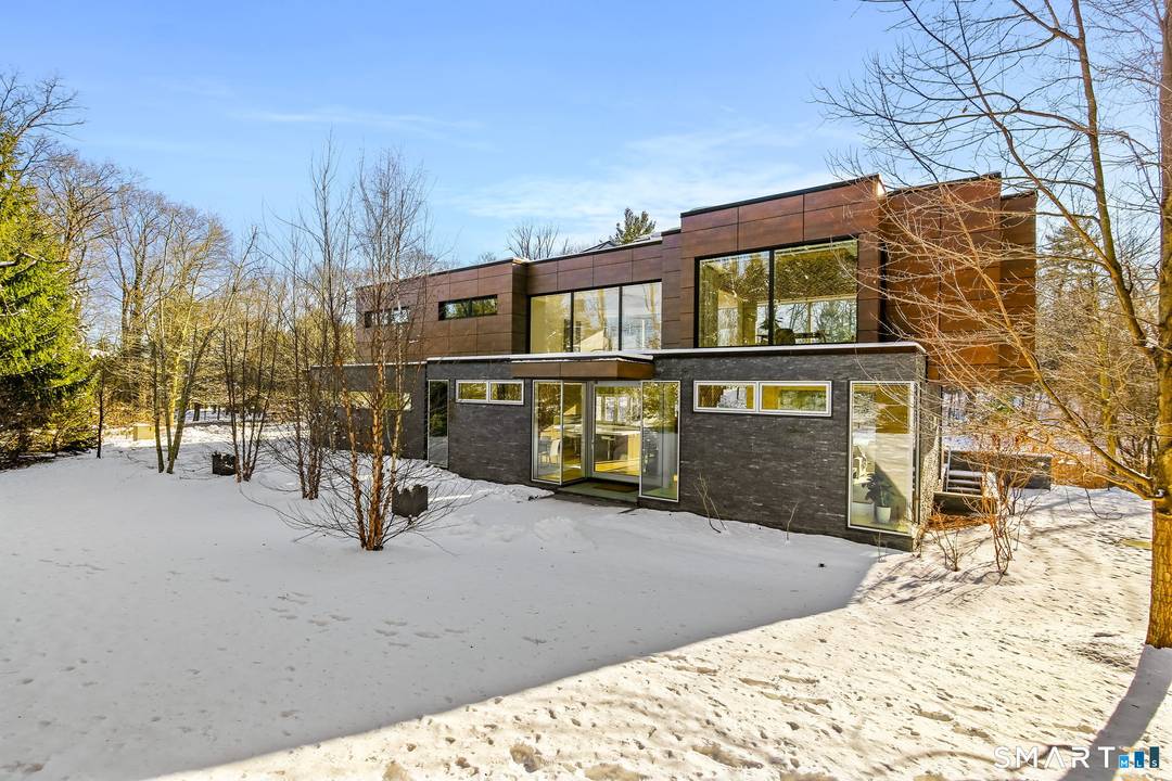 Set on over two private acres with its own pond and just one mile from town, this architecturally significant modern residence is a rare convergence of design, technology, and setting.