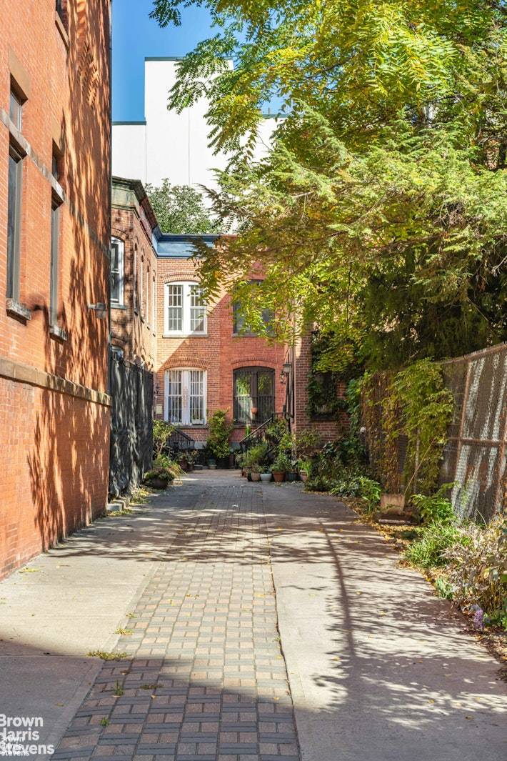 Behind a discreet wrought iron fence, discover a paved street lined with charming 1899 red brick Italianate townhouses.
