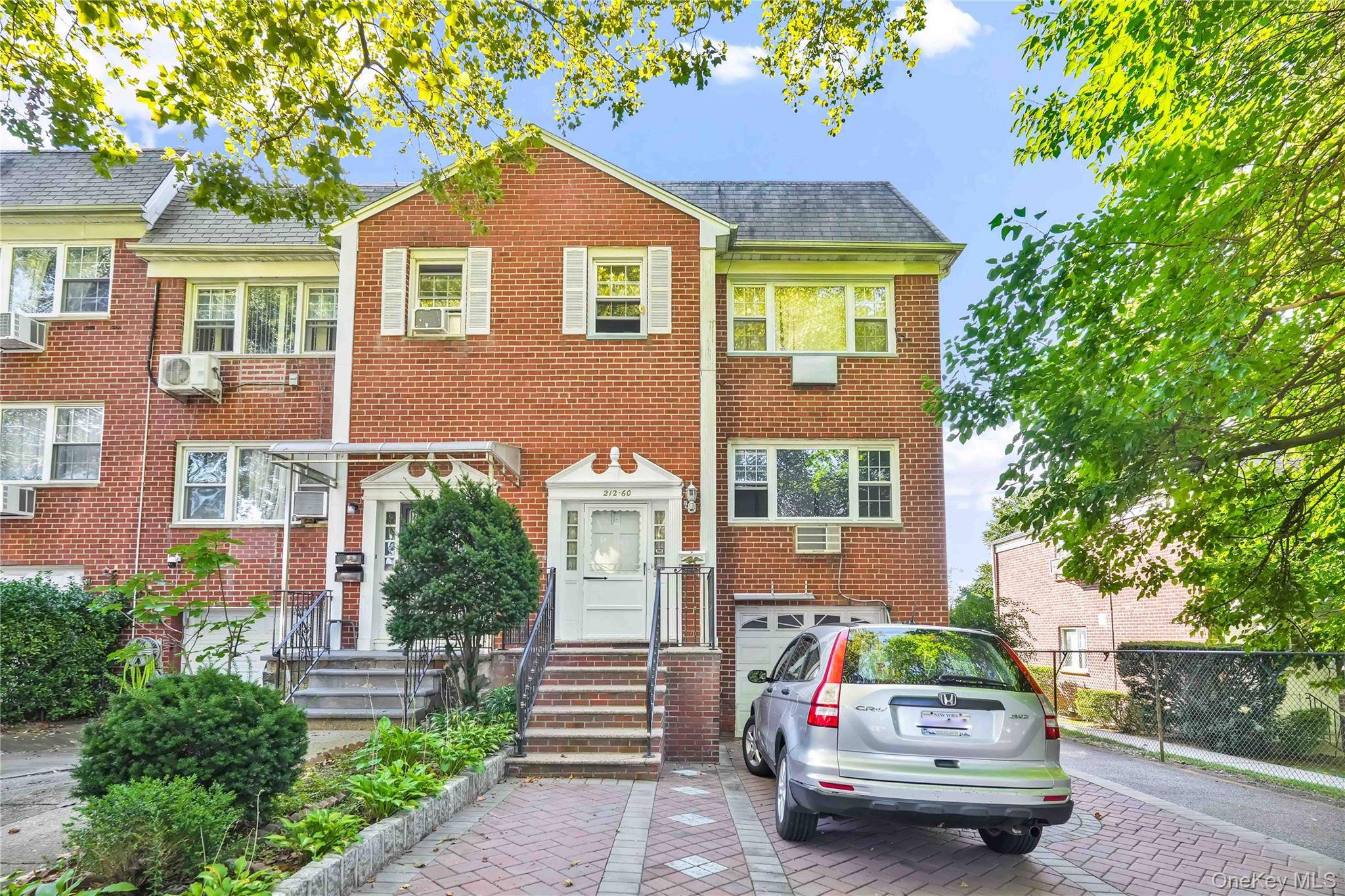 Semi attached two family house sun drenched with two skylights and spacious units.