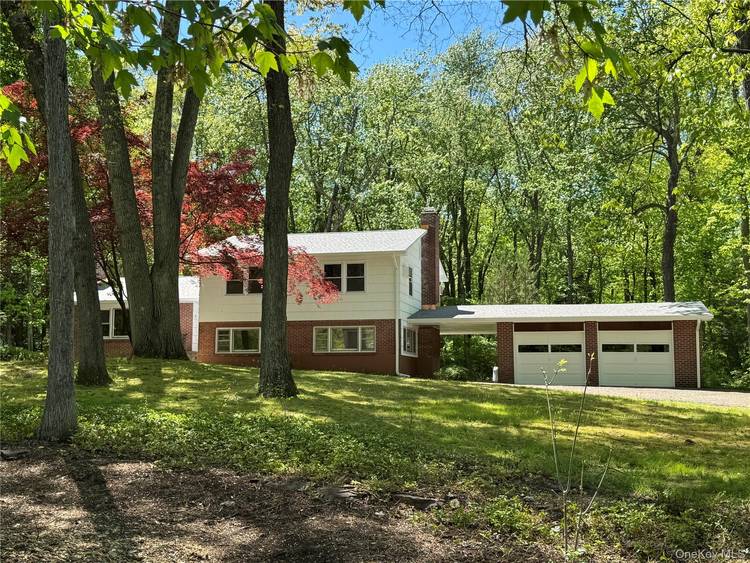Nestled in a wooded setting, this beautifully refreshed split level home offers both privacy and convenient access to major roads and amenities.
