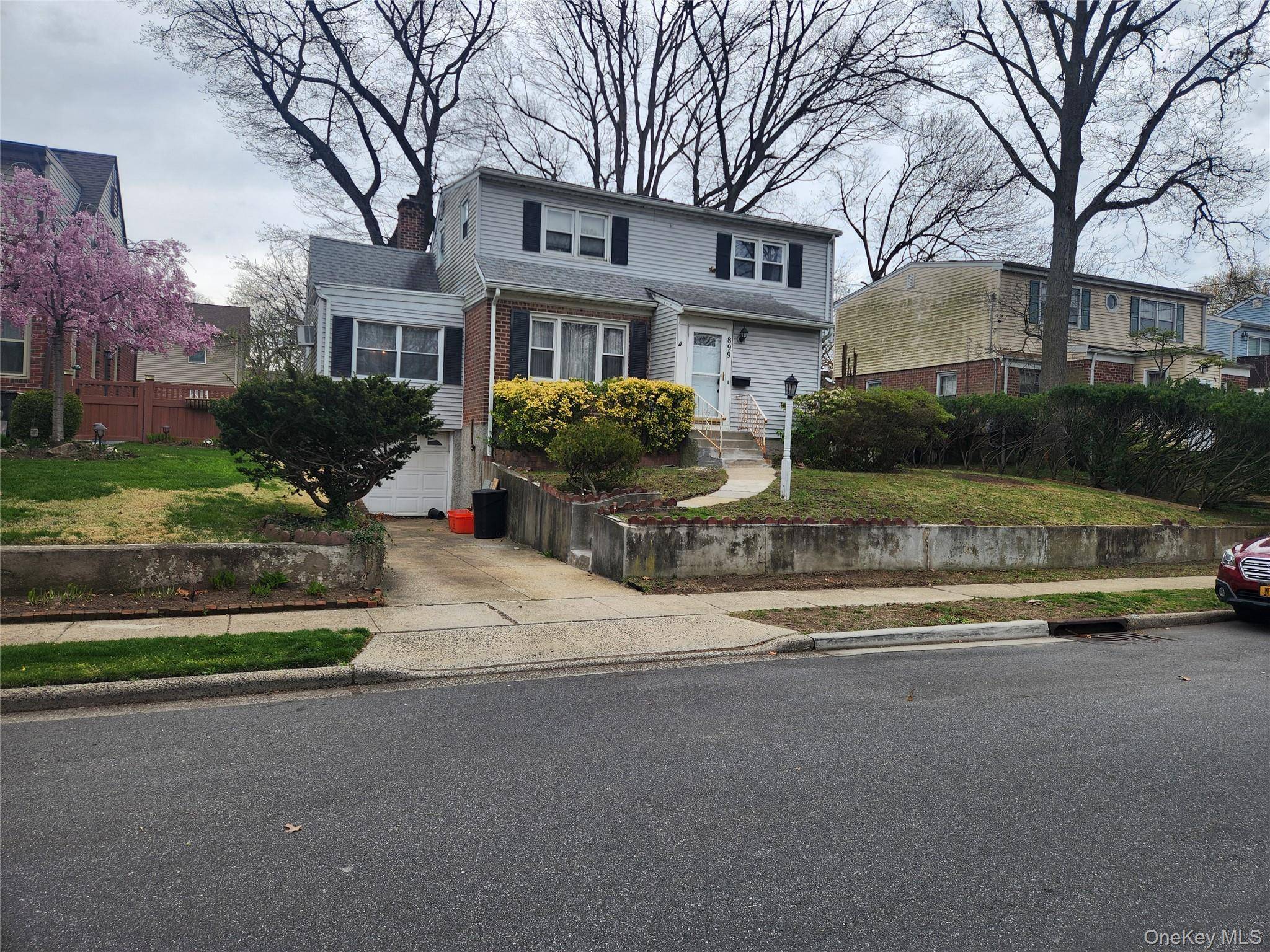BRICK SIDED HOME ON TREE LINED STREET.