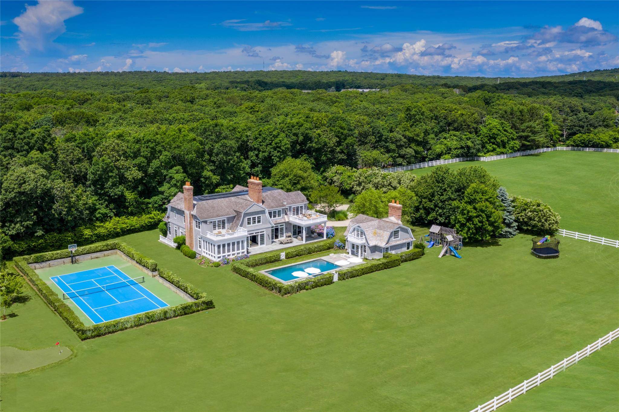 Escape to Hamptons horse country in this remarkable Water Mill Estate, offering an unparalleled lifestyle with a pool, pool house and tennis court, overlooking open land, polo fields and stables.