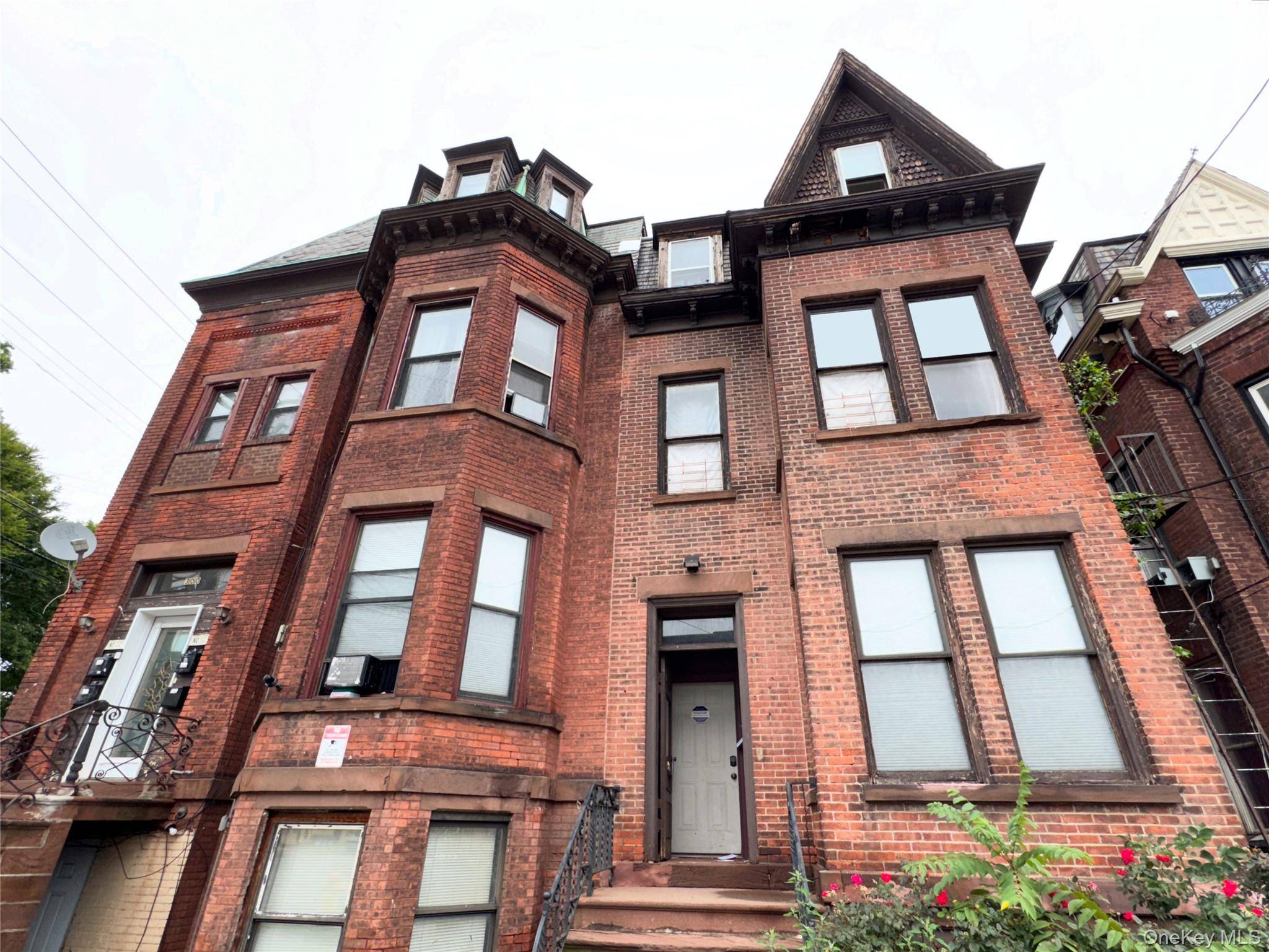 Attached brick Legal three family in need of interior repair.
