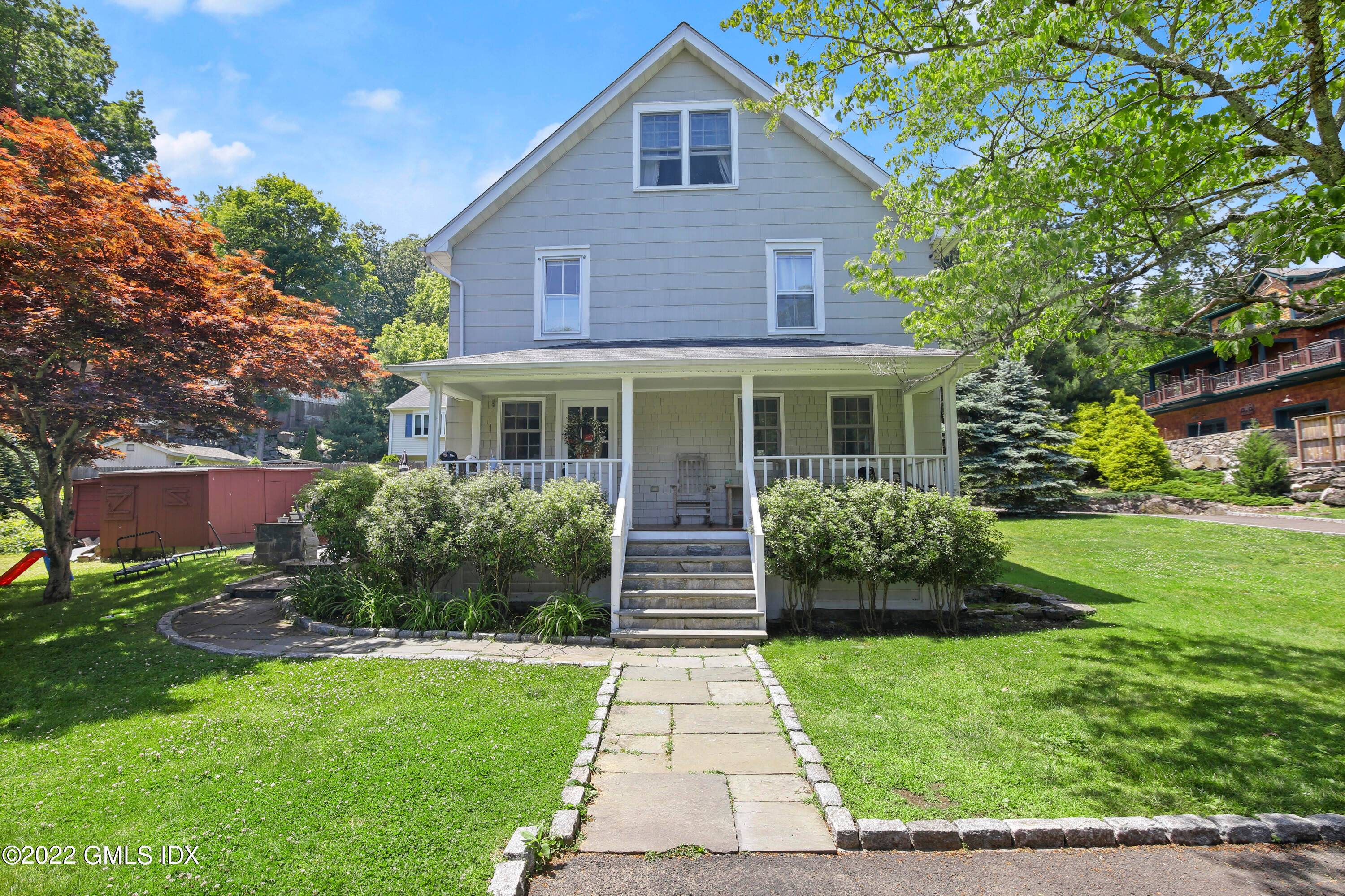 Wonderful front porch and stone terrace, ideal for both relaxation as well as entertaining, enhance this sun drenched three bedroom home set back on.