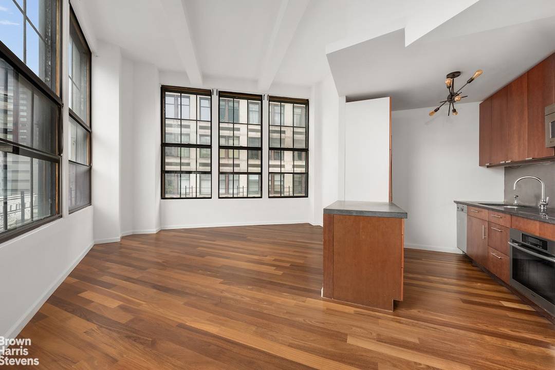 This bright corner 2 bedroom 1 bathroom loft offers soaring 13 foot concrete ceilings, wood floors, nine 10' cast iron casement windows facing North, East, and West.