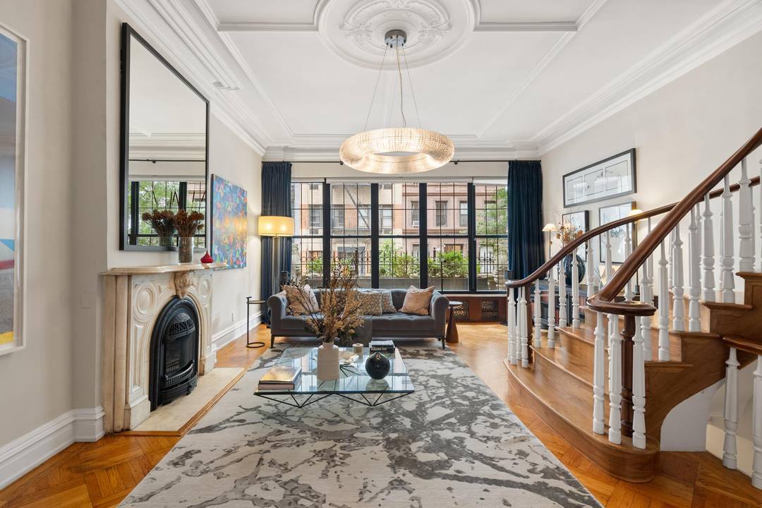 Turnkey UES townhouse with rare garage, lush garden, and sun filled interiors.