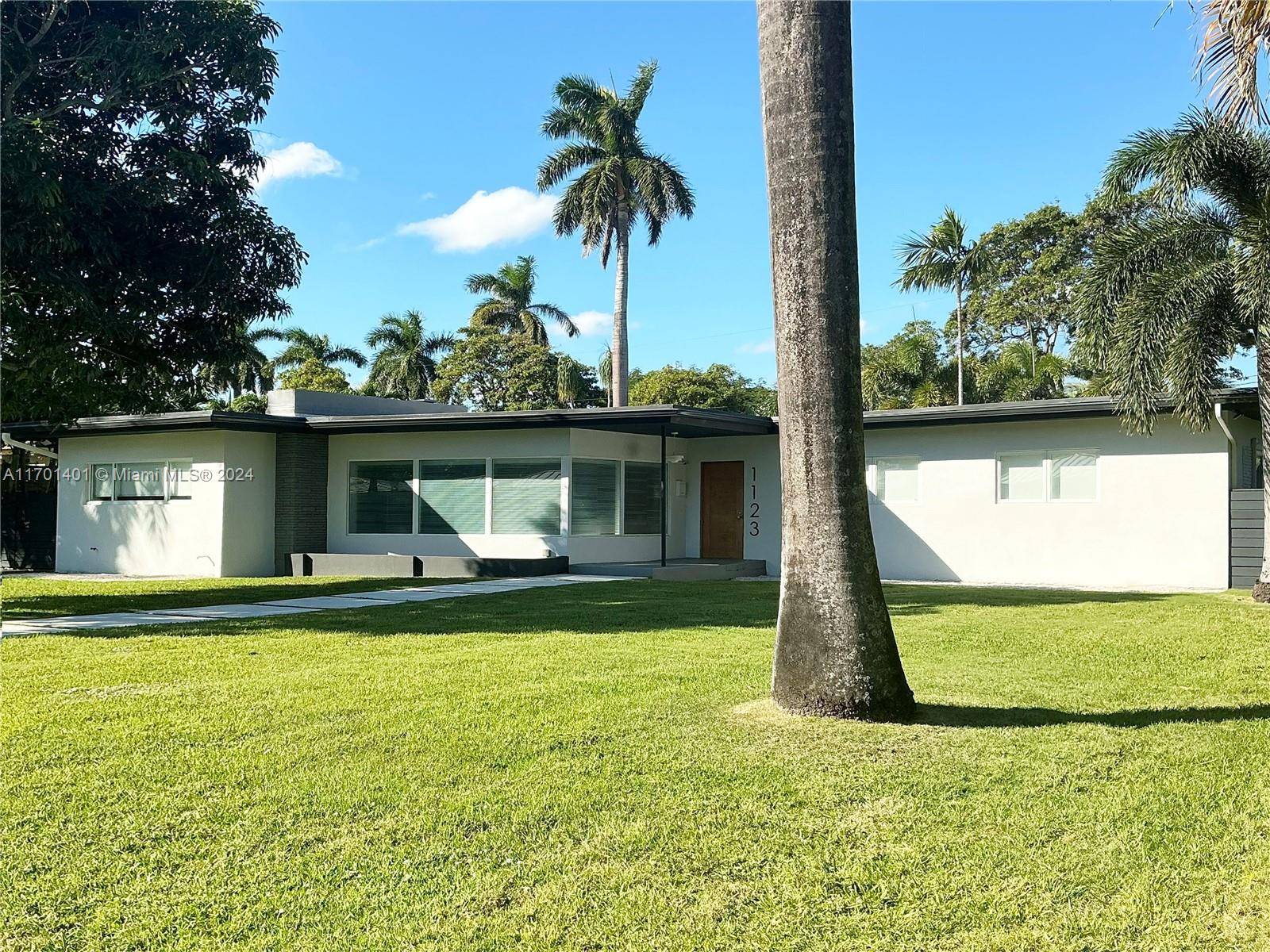 This beautiful mid century modern home sits on a large double lot in the exclusive community of Hollywood Lakes.