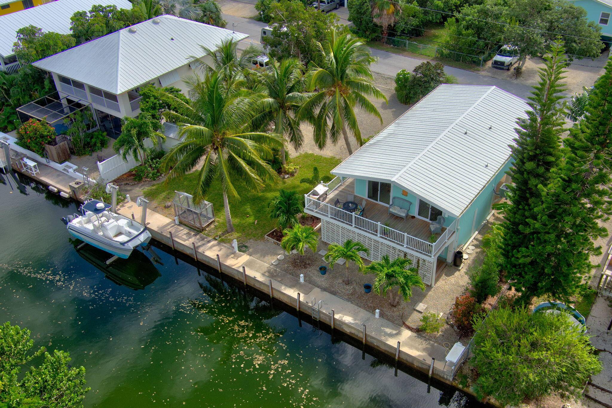 This beautiful Florida Keys home sits on TWO FULLY FENCED LOTS and has 100' of canal frontage with a concrete seawall and a 15, 000 boat lift.