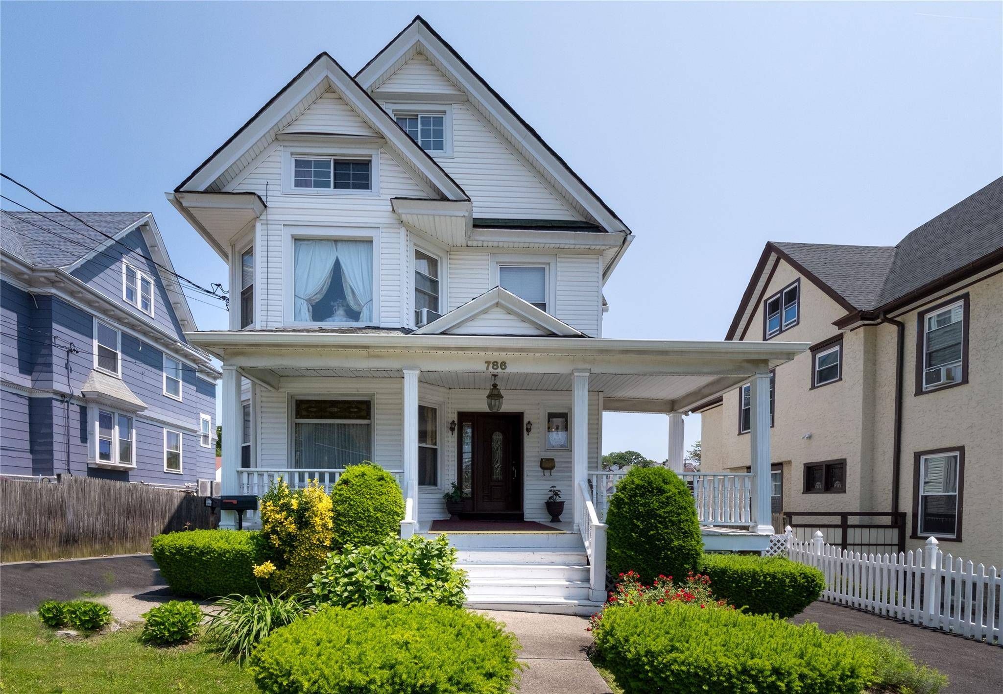 Step into the timeless charm of this 1917 Victorian home through a welcoming foyer adorned with original woodwork, classic wainscoting, and beautiful preserved hardwood floors.