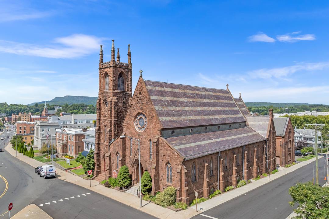 Built in 1870, this gable roofed Romanesque Revival, 22, 856 square foot, historic brownstone was designed by Henry Dudley of New York, known for Gothic Revival churches.