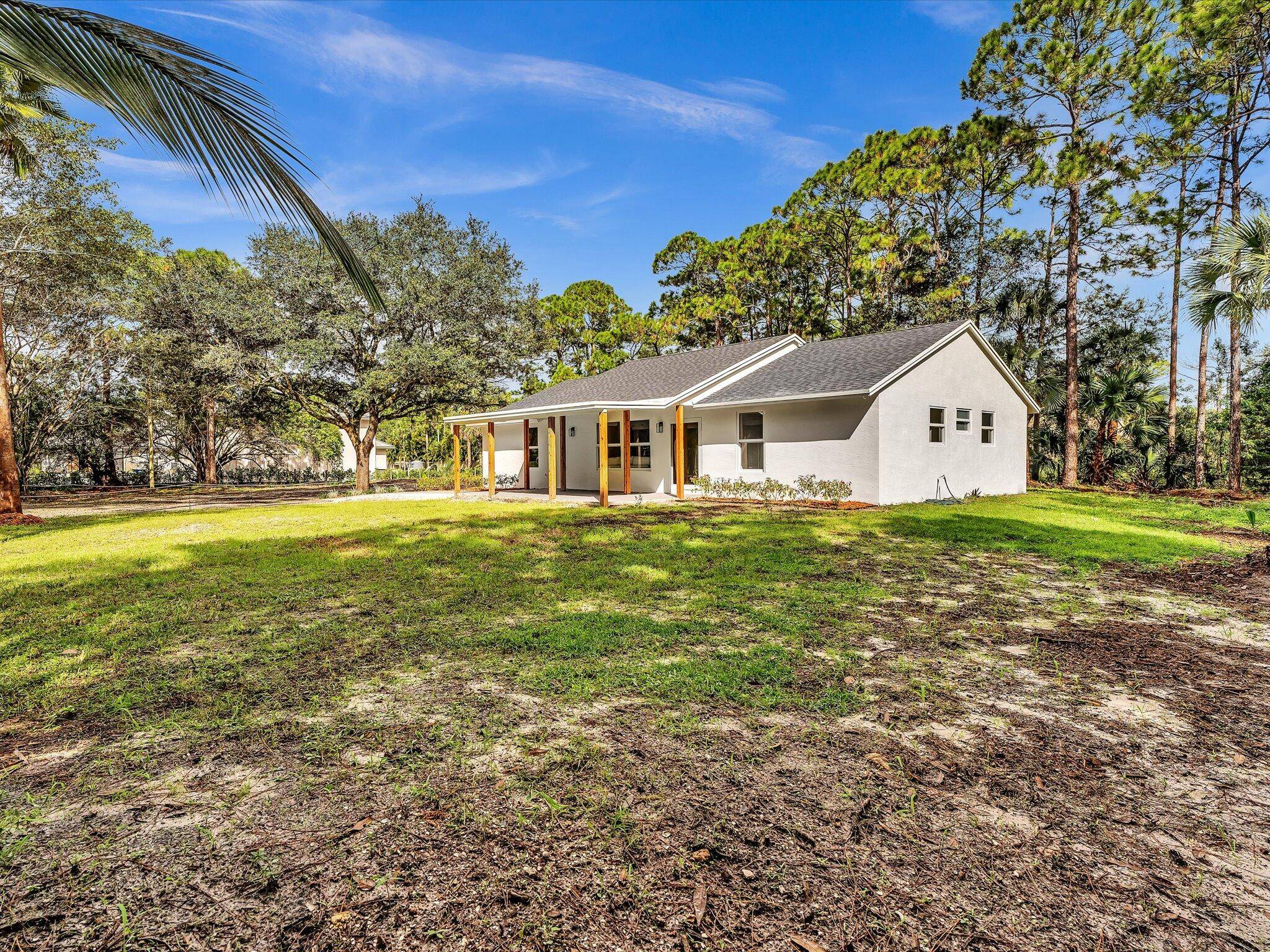Experience peaceful modern living in The Acreage with this fully remodeled home on 1.