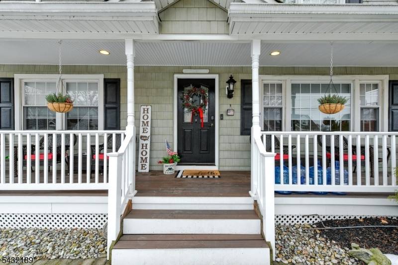 Sprawling custom Colonial with charming lemonade porch offering 5 bedrooms, 4 full baths, and 1 half bath designed for comfortable living and entertaining.