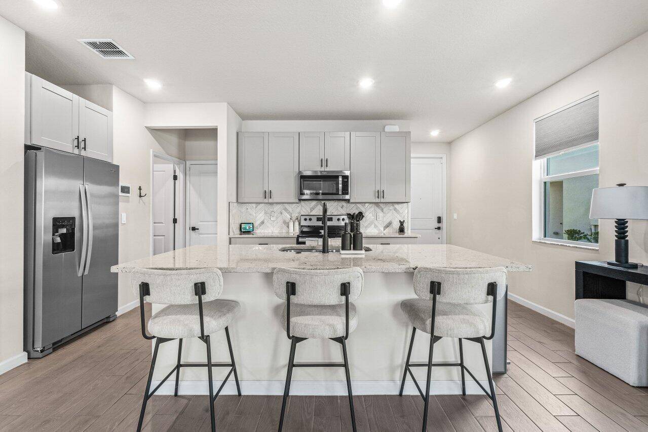 Discover this newly built 2022 end unit townhome in the gated Enclave at Mangonia community.
