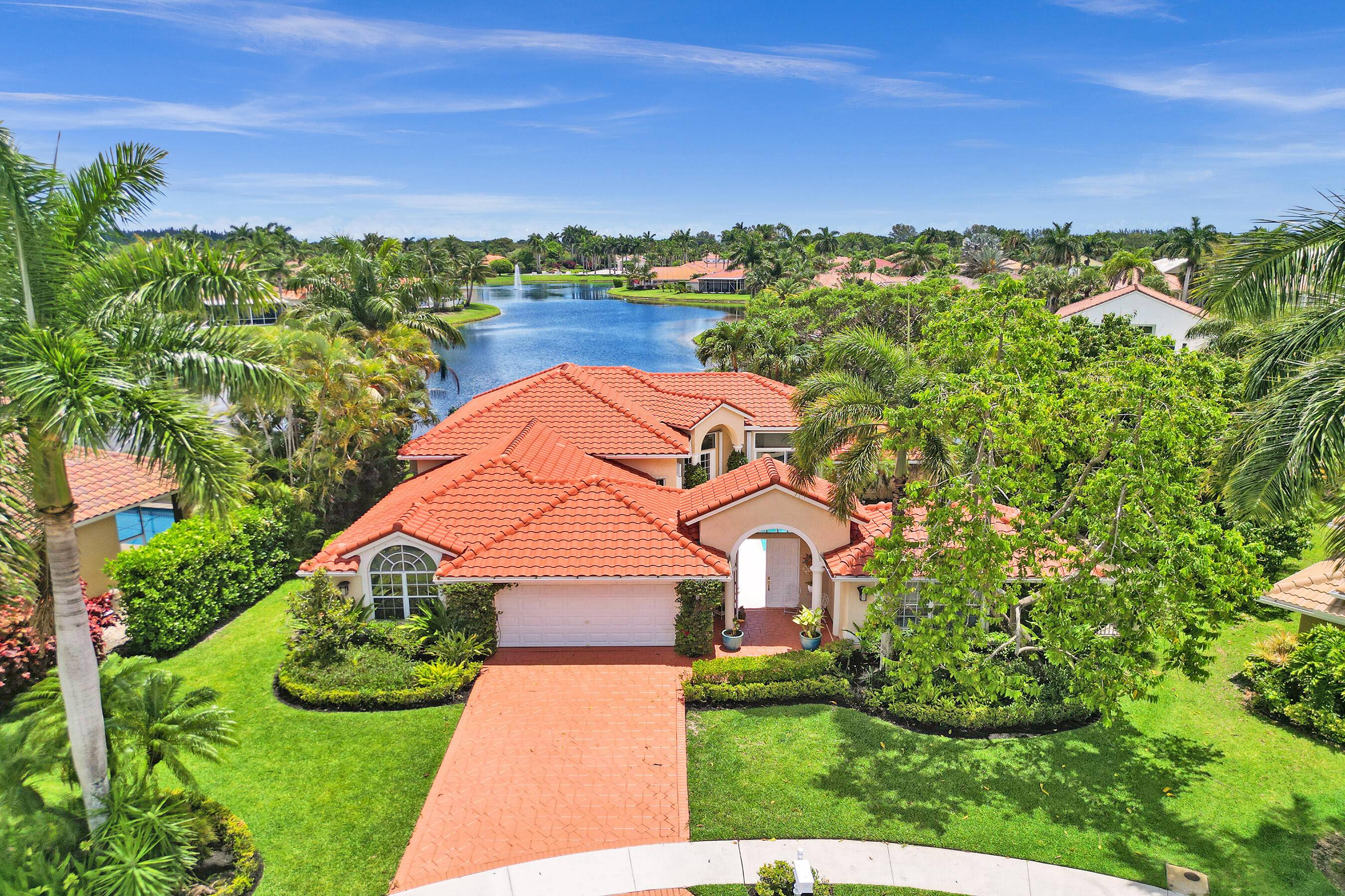 Tropical 4BR 3BA Brazilian courtyard home in Boca Isles North on a pie shaped cul de sac lot with stunning lake and Boca Isles fountain views.