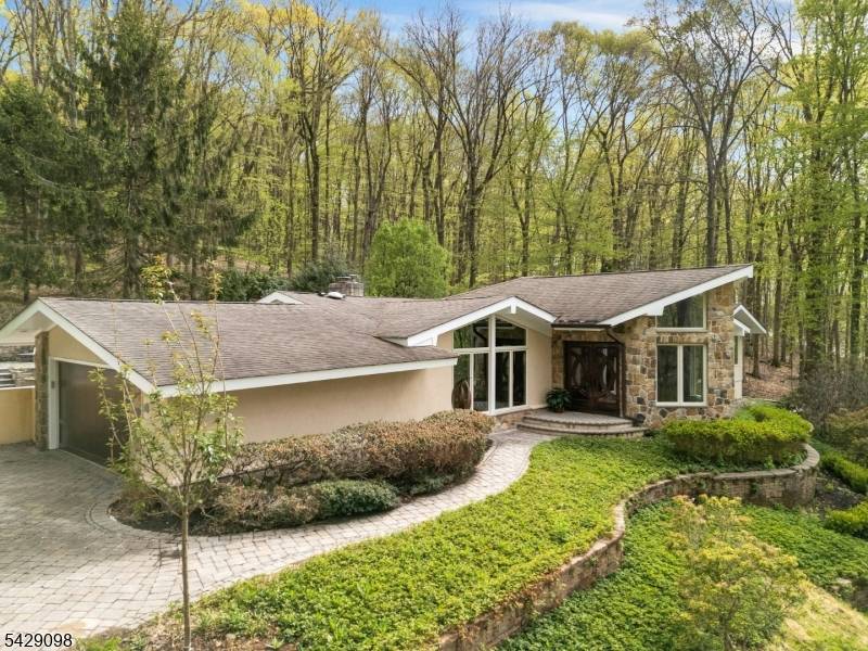 Set atop a gently sloping wooded 5 acres, this exceptional contemporary ranch offers a blend of privacy, sophistication, and effortless indoor outdoor living.
