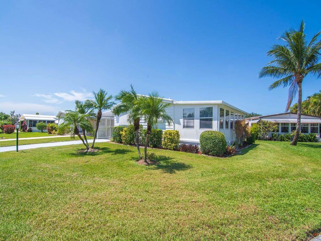 Welcome to 66 Pinelake Village Blvd, Jensen Beach, FL a charming double wide home nestled in the heart of a vibrant 55 community just minutes from the ocean.