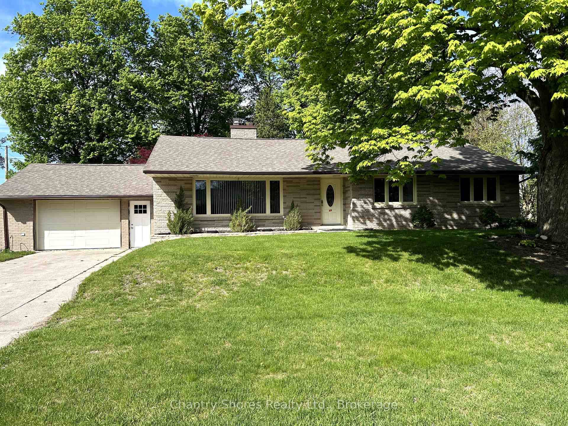 Rarely offered large brick bungalow with attached garage on a lovely mature double corner town lot 132' x 132'.