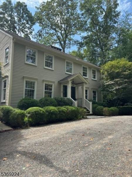 Located in a highly desirable, convenient location sits a traditional Colonial style four bedroom home privately set on a hill fronted by a stacked stone wall.